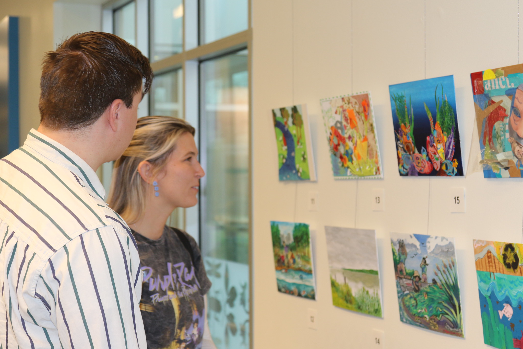 People viewing art on the walls at the Delaware Museum of Nature & Science.